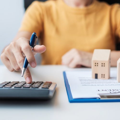 Woman using calculator during signing home contract documents. Contract agreement, real estate,  buy and sale and insurance concepts